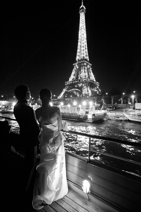 Mariés sur une péniche regardant la tour Eiffel