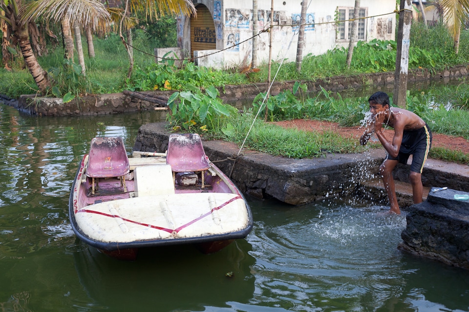 Adolescent se nettoyant le visage dans l'eau des backwaters