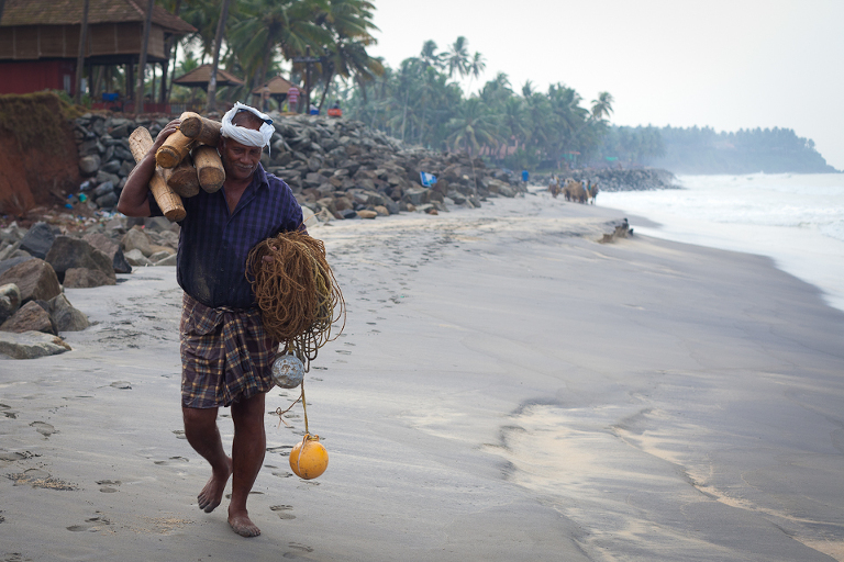 Pêcheur indien marchant sur la plage