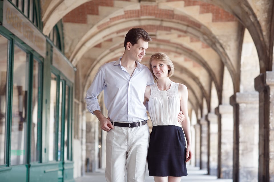 Amoureux marchant sous les arcades de la place des Vosges