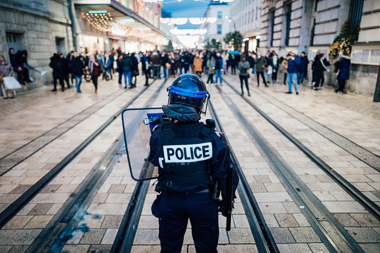 Policier devant une foule de manifestants