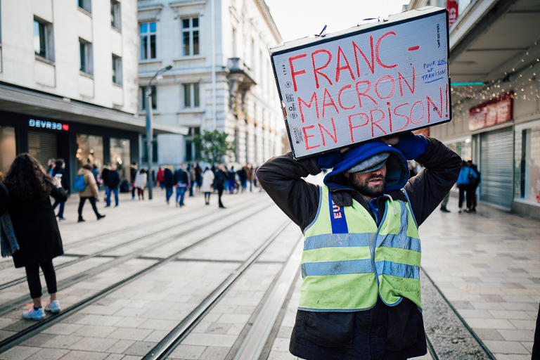 Gilet jaune brandissant une pancarte