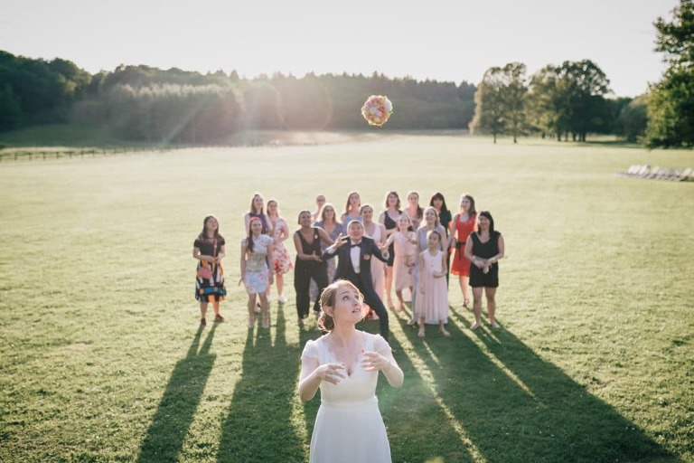 Photo de lancer de bouquet pendant le cocktail de mariage